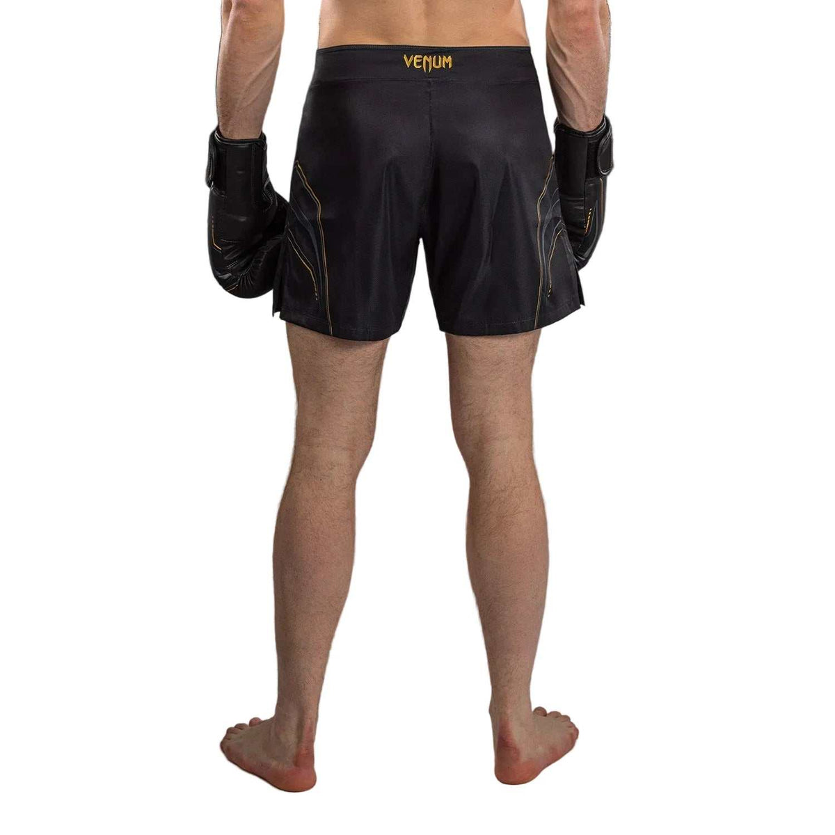 Short de combat noir en polyester, orné de détails dorés et d’une coupe ample avec fentes latérales.