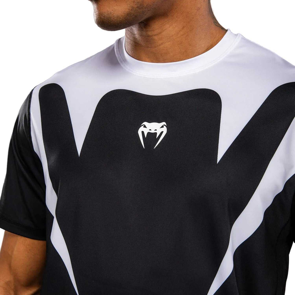 T-shirt Venum Attack blanc et noir en tissu technique, col rond et manches courtes, motif graphique contrasté.