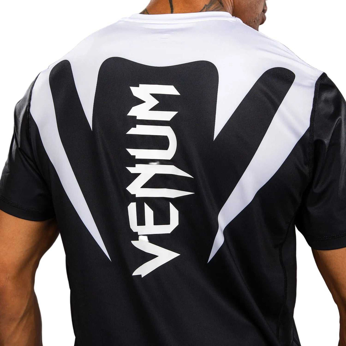 T-shirt Venum Attack blanc et noir en tissu technique, manches courtes et grand logo Venum au dos.