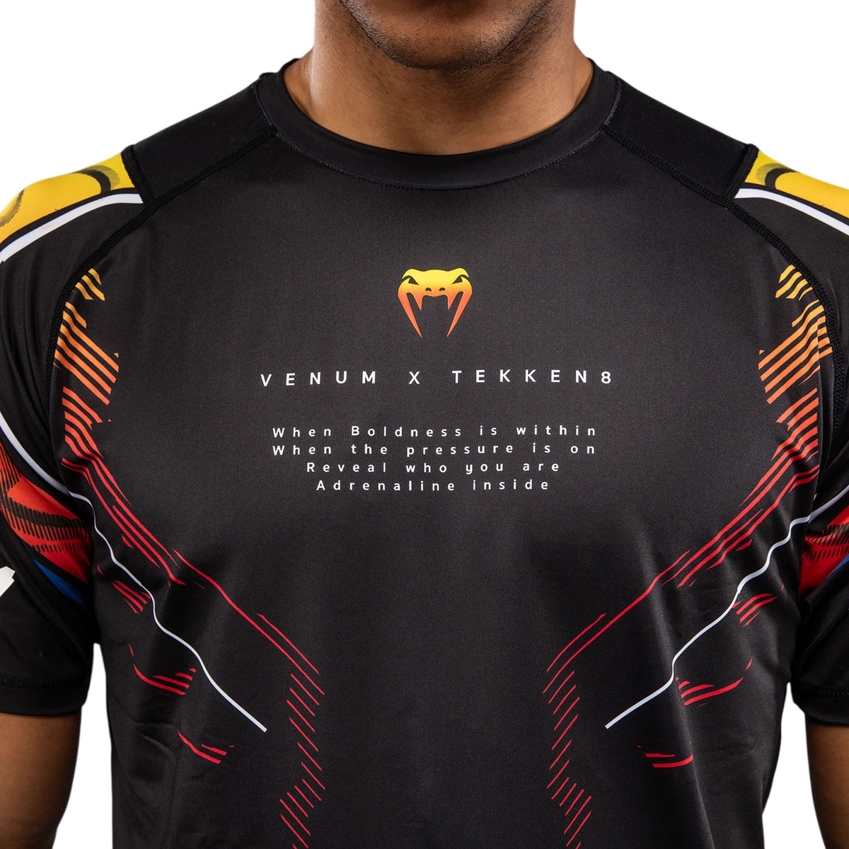 T-shirt Venum noir en tissu technique, motifs graphiques orange et rouges, logos TEKKEN 8 et col rond