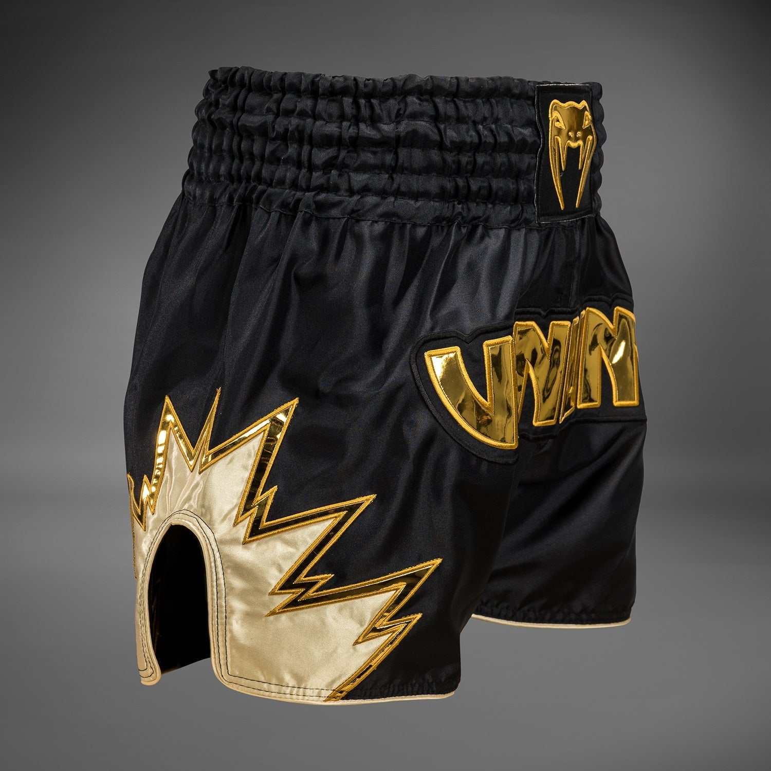 Short de Muay Thaï Venum Inferno noir et or léger à séchage rapide avec fentes latérales et ceinture traditionnelle.