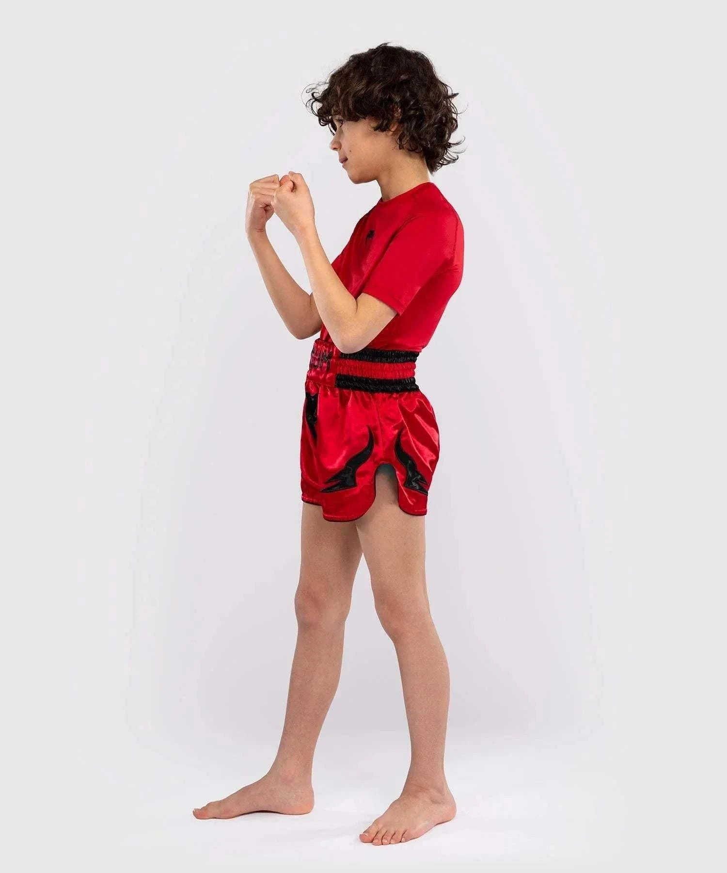 Child wearing red Short Muay Thai Venum Inferno with side slits for martial arts training
