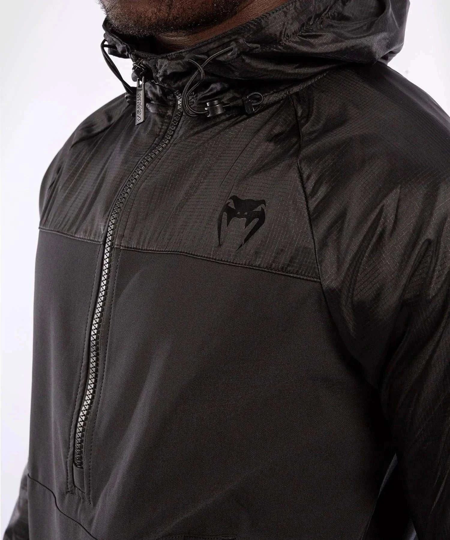 Black Venum Laser XT hooded sweatshirt with adjustable hood and front zipper, featuring printed graphics and water-resistant fabric.
