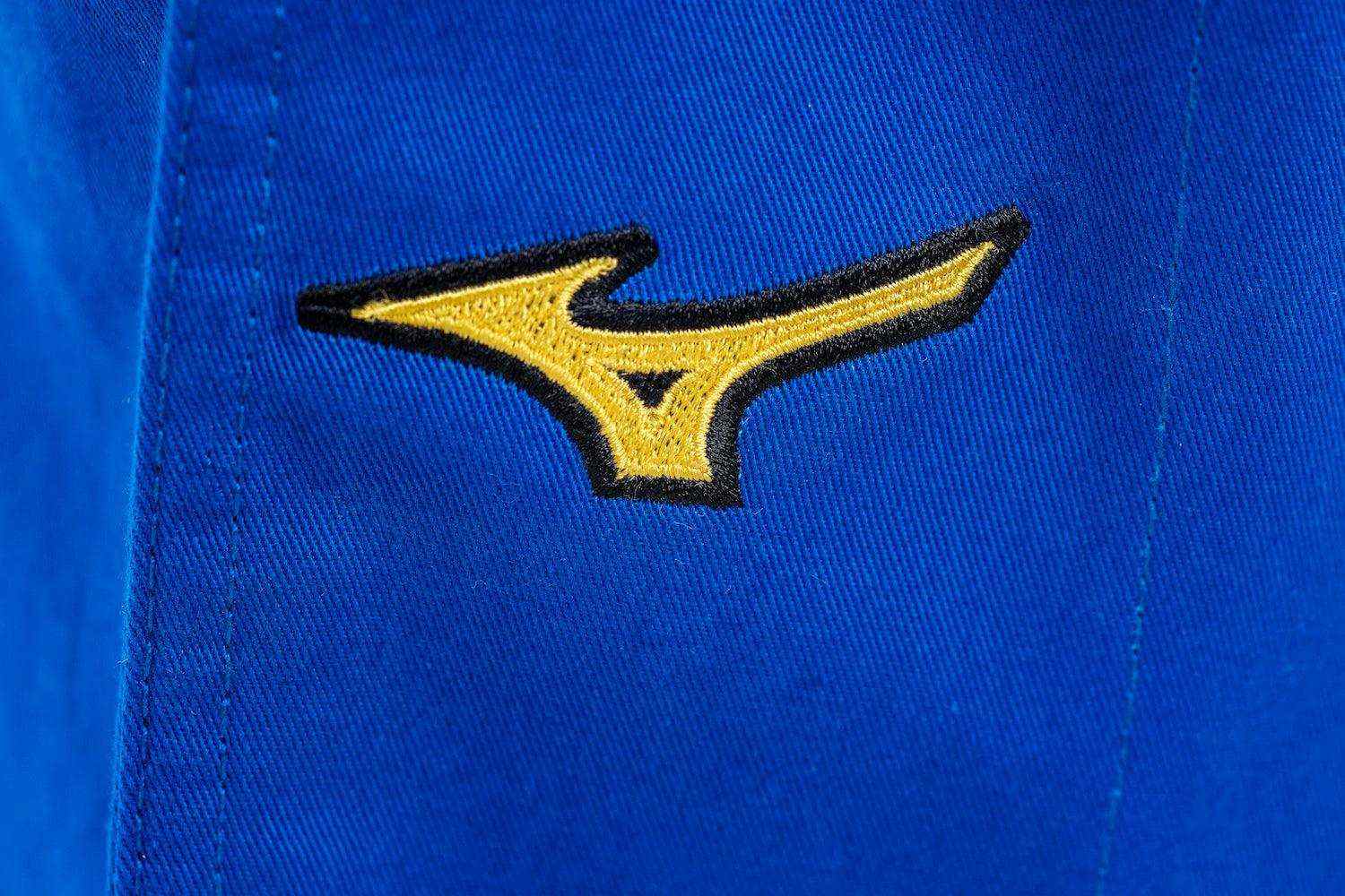 Close-up of yellow Mizuno logo embroidered on blue Kimono Judo Mizuno fabric