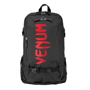 Sac à dos Venum noir en textile, avec grand logo rouge, poches zippées et sangles de maintien.