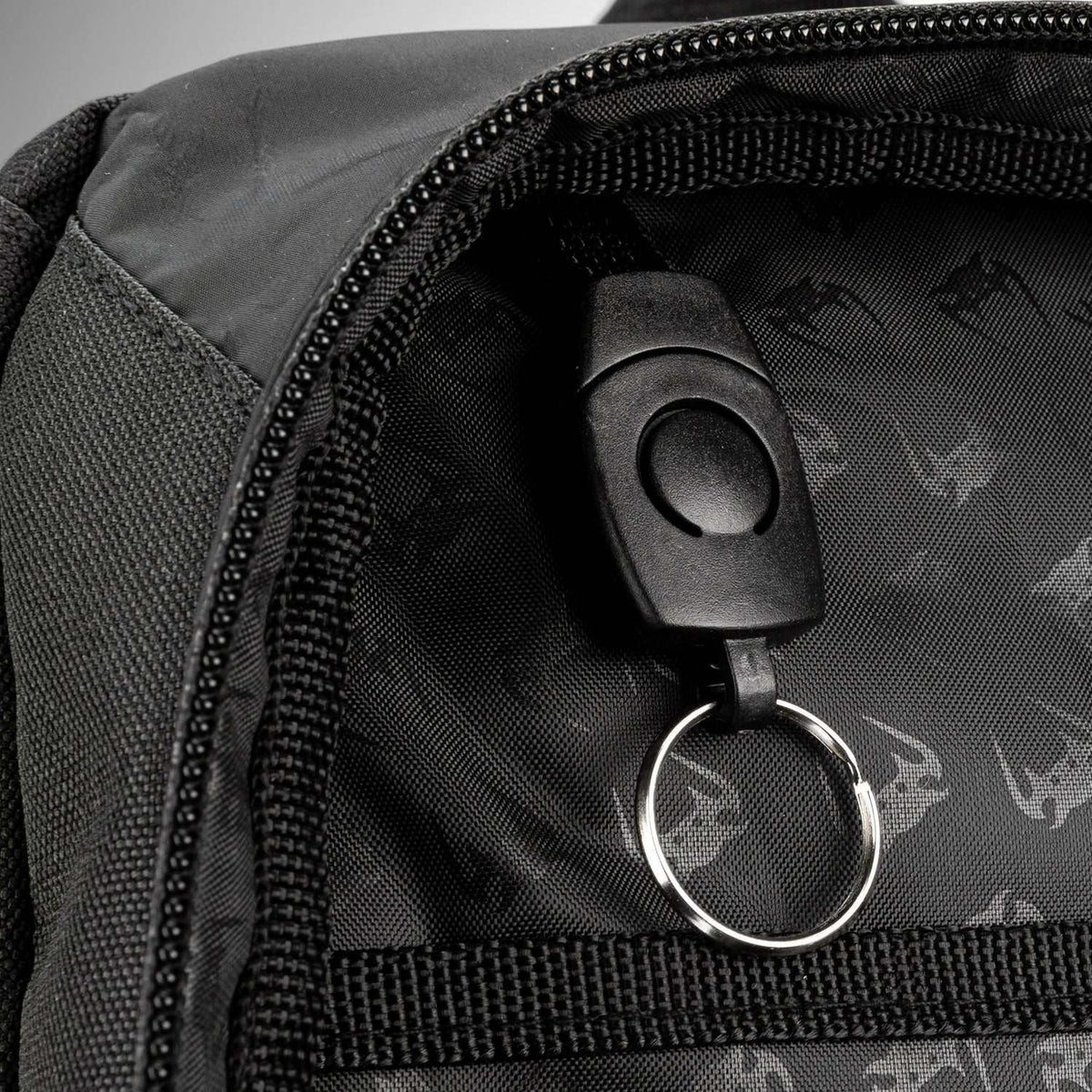 Sac à dos noir en textile, avec doublure imprimée Venum et anneau porte-clés intégré découpé.