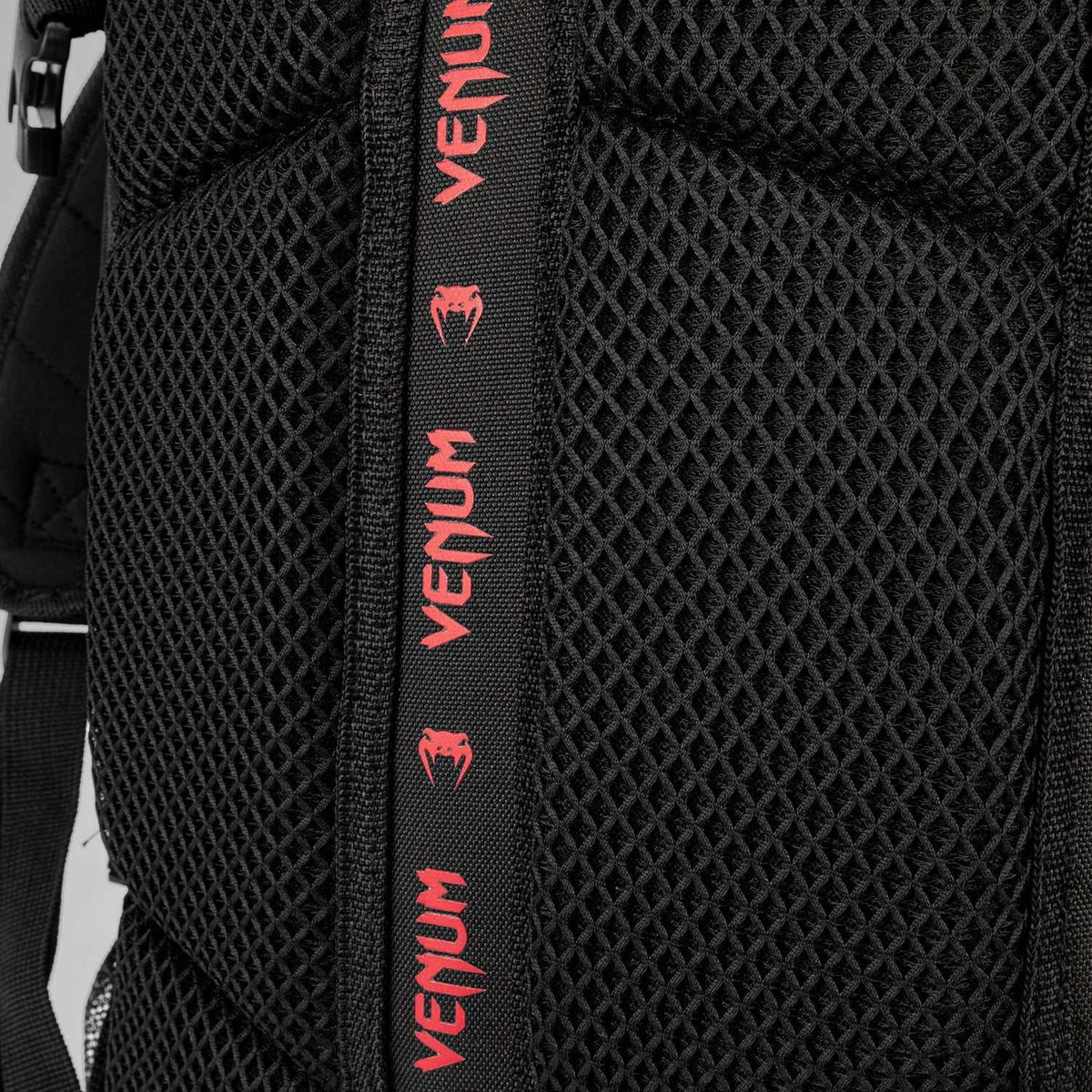 Sac à dos noir en tissu mesh rembourré, avec sangle centrale ornée de logos Venum rouges répétés
