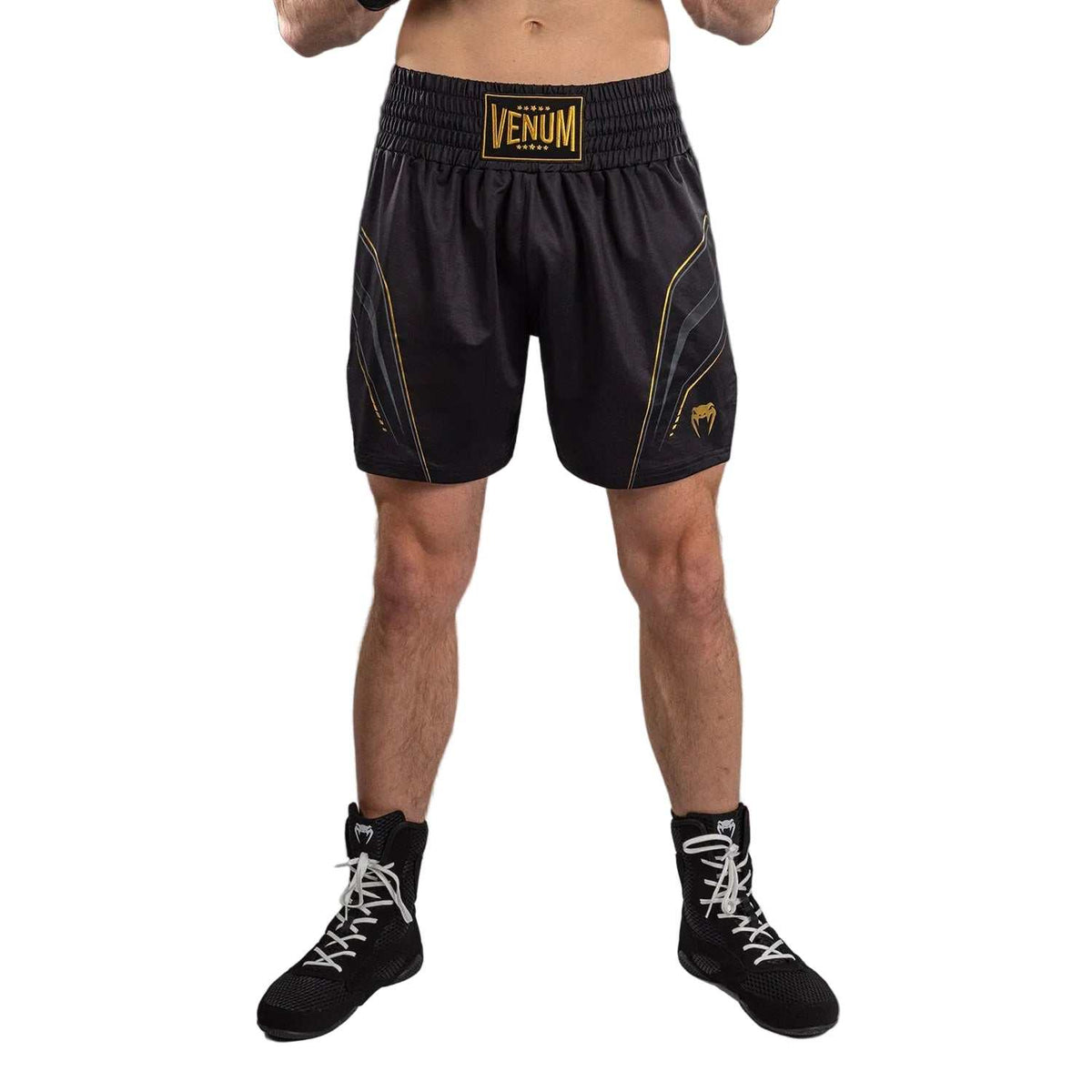 Short de boxe anglaise noir en tissu technique, avec détails dorés, ceinture élastique et logos Venum visibles