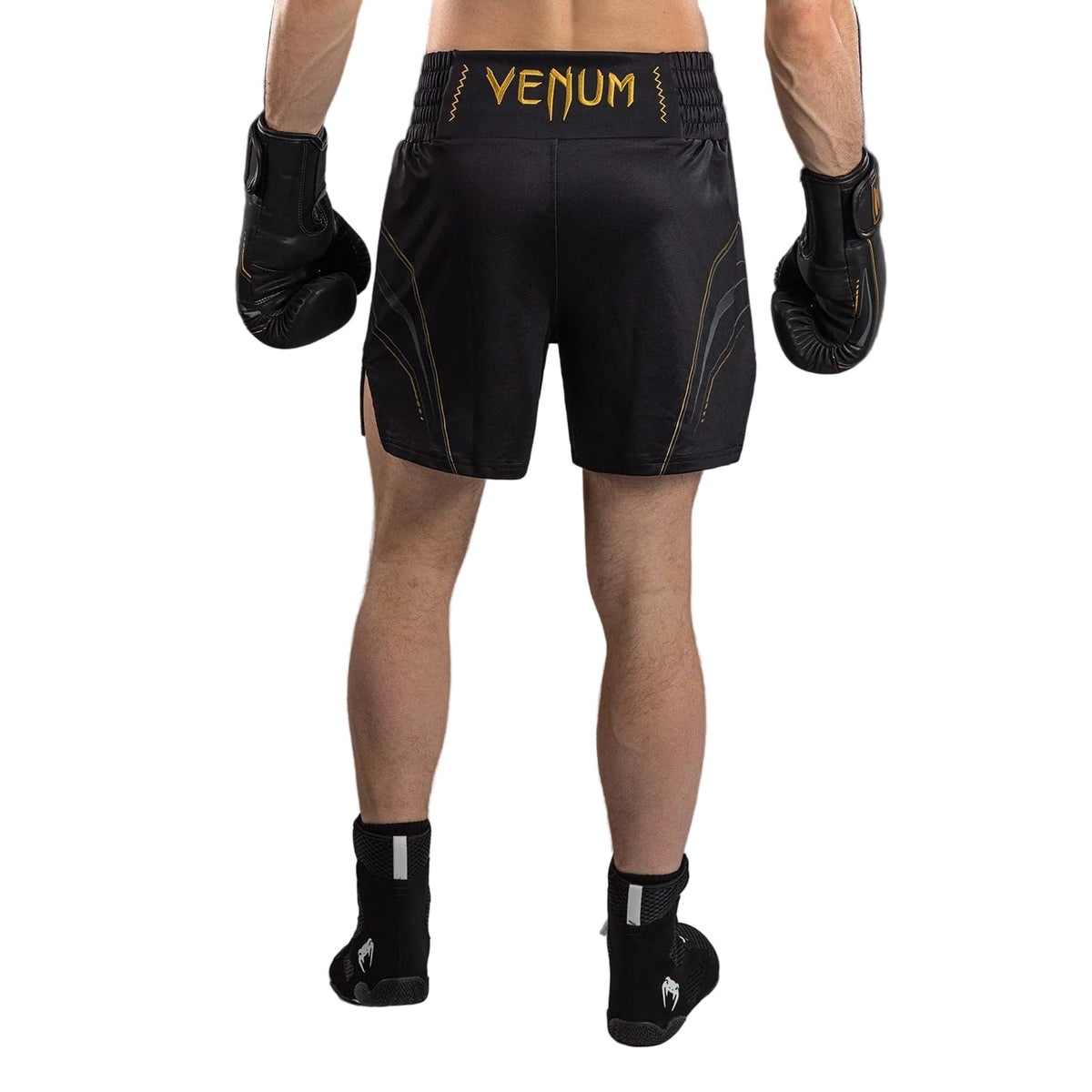 Short de boxe anglaise noir en tissu technique, avec logo Venum doré et motifs graphiques dorés sur les côtés.
