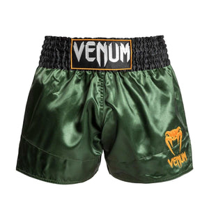 Short de Muay Thai vert foncé en polyester satiné, ceinture noire et logo Venum orange sur la jambe.