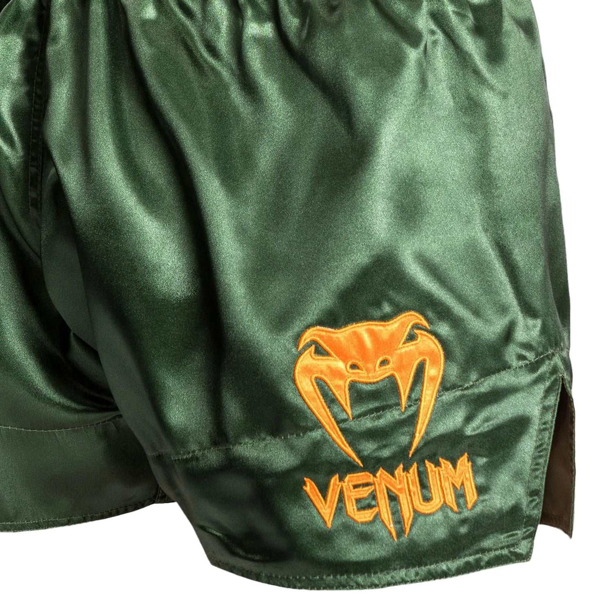 Short de Muay Thai vert en polyester satiné, avec logo Venum orange brodé et fente latérale visible