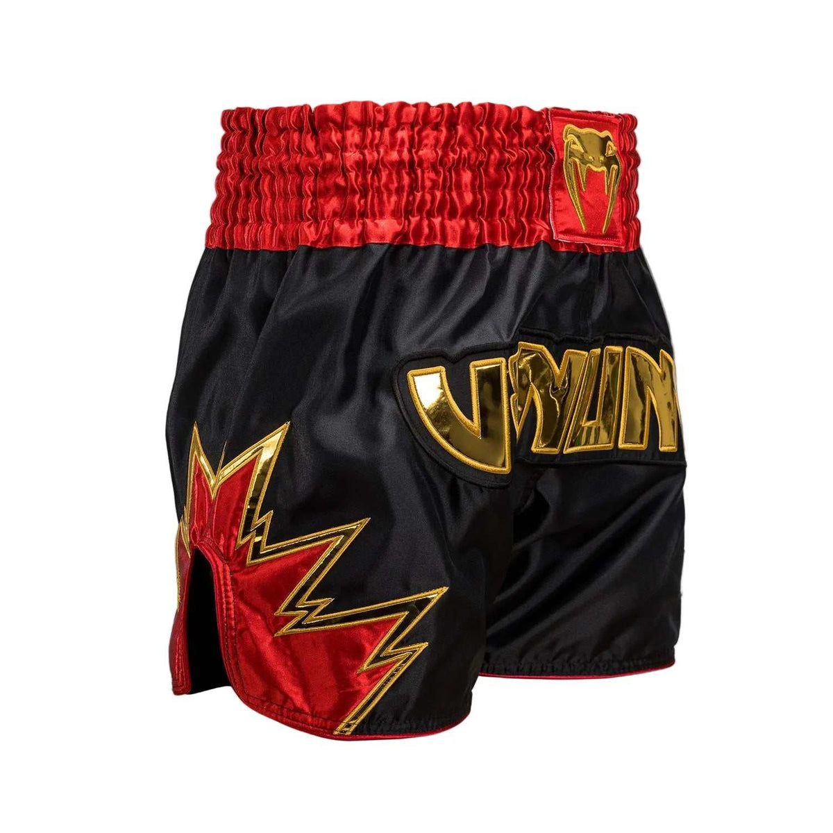 Short de Muay Thai noir en satin, avec ceinture rouge et motifs dorés, logo Venum et fentes latérales