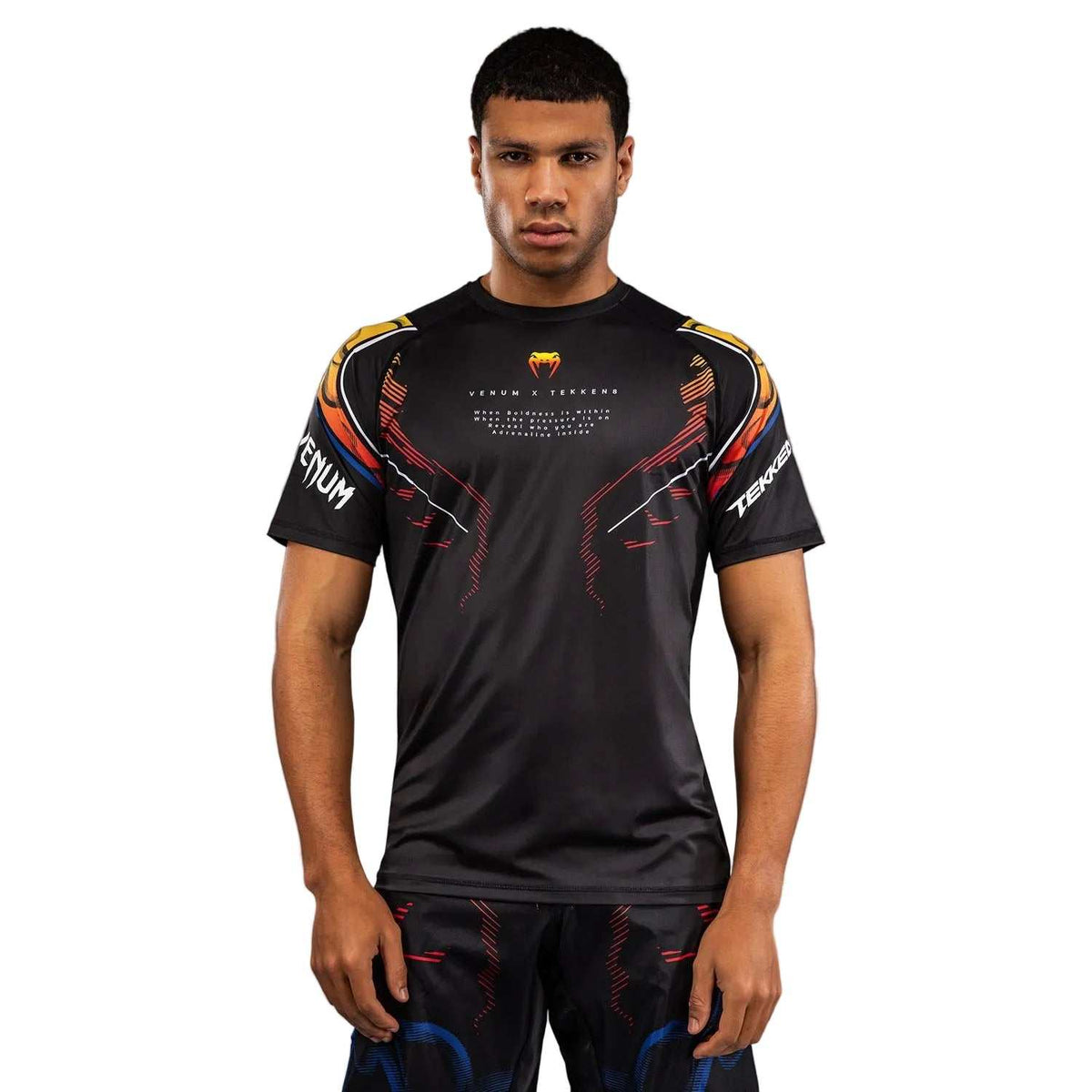 T-shirt Venum noir en tissu technique, manches courtes et motifs graphiques orange, logos Venum et TEKKEN 8 visibles.